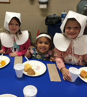 three elementary students dressed up as pilgrims